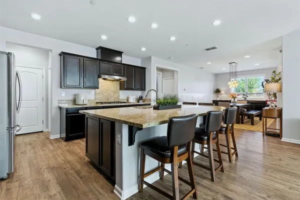 a living room with furniture kitchen view and a potted plant