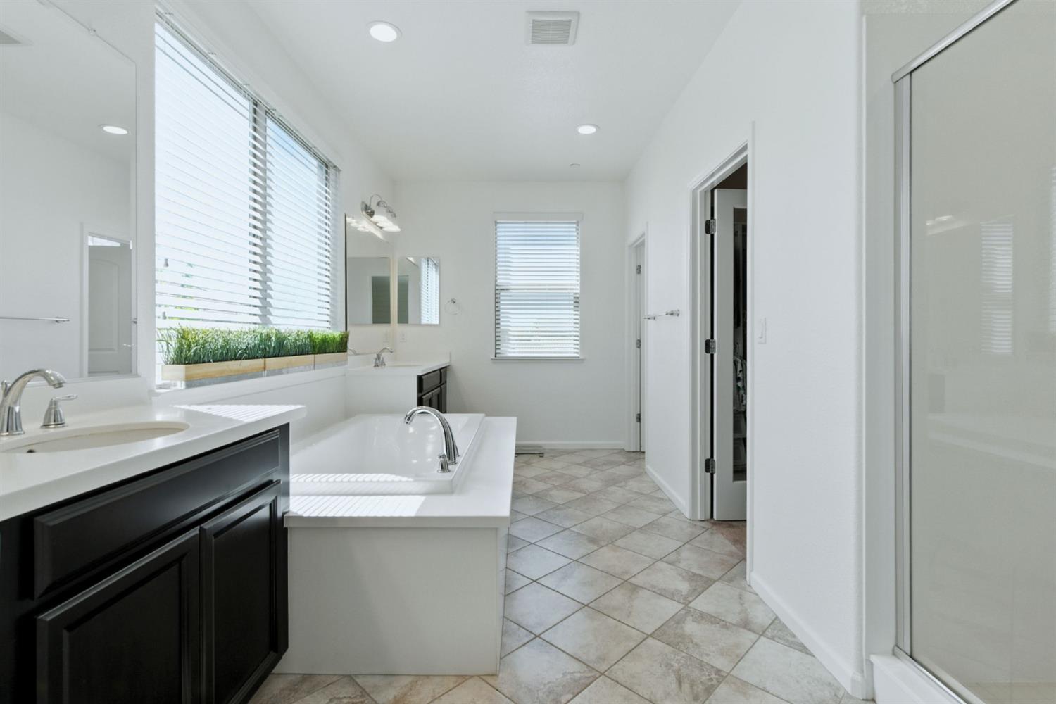 18200 Broadmoor Way Lathrop, CA 95330 - Photo 32 of 48 bathroom featuring a stall shower, two vanities, a bath, recessed lighting, and light tile patterned floors