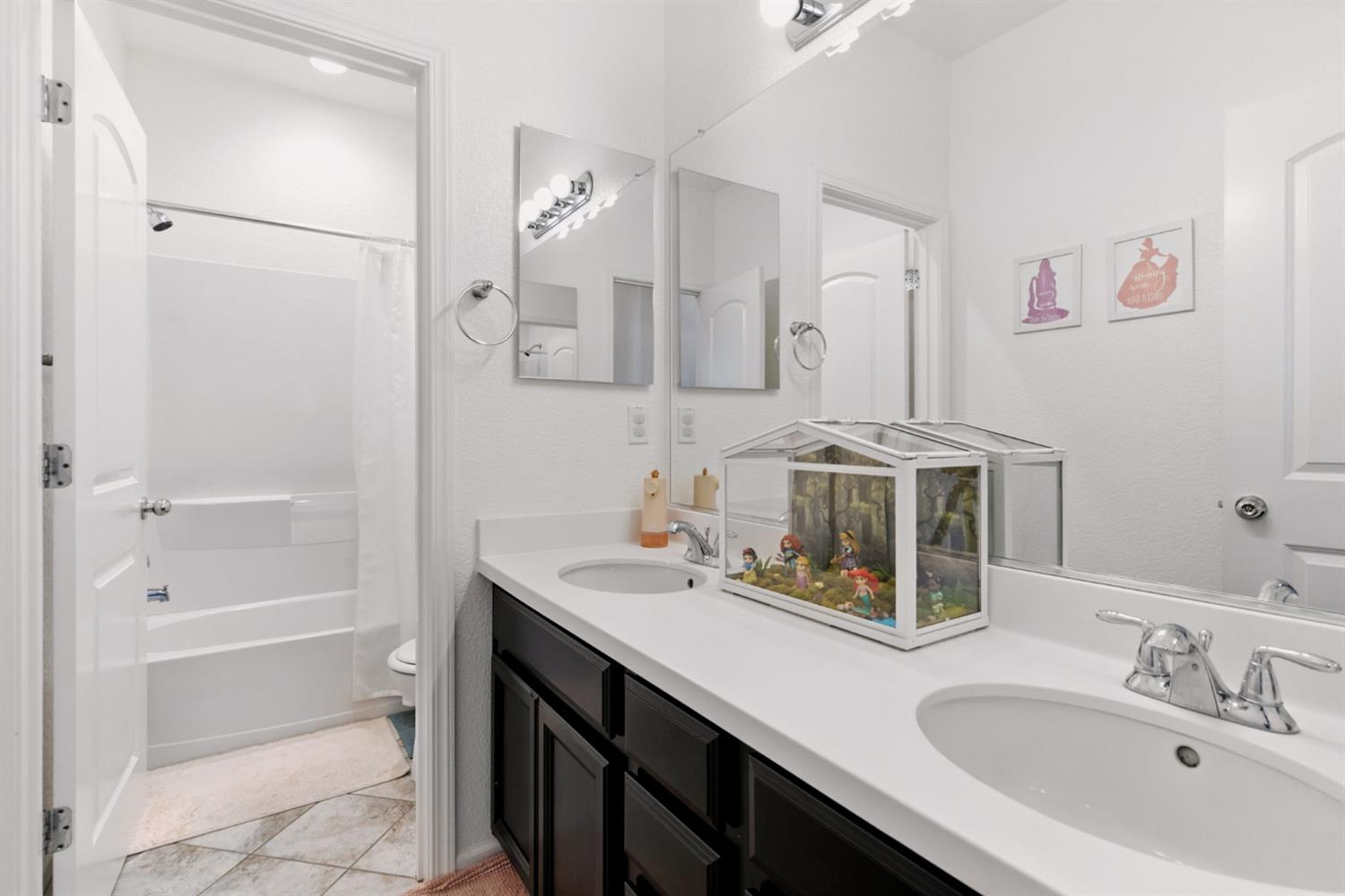 18200 Broadmoor Way Lathrop, CA 95330 - Photo 35 of 48 bathroom with shower / bath combo with shower curtain, double vanity, and light tile patterned floors