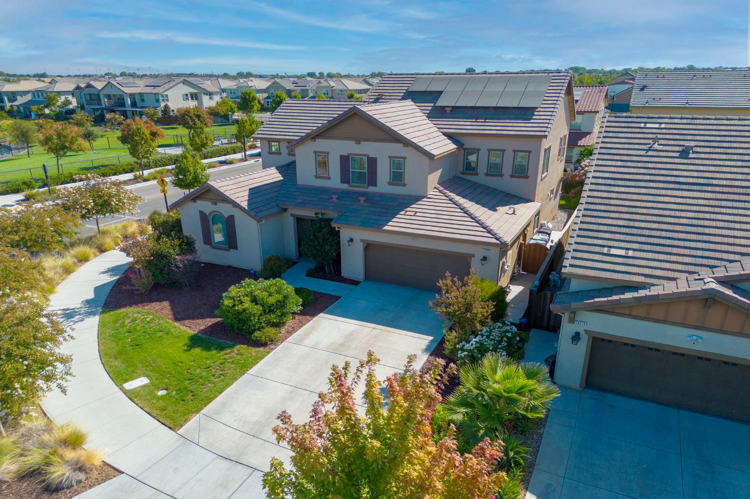 18200 Broadmoor Way Lathrop, CA 95330 - Photo 44 of 48 view of front facade featuring roof mounted solar panels, concrete driveway, stucco siding, a residential view, and an attached garage