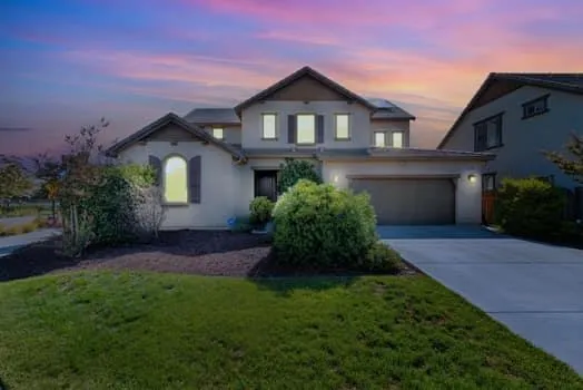 a front view of a house with a garden