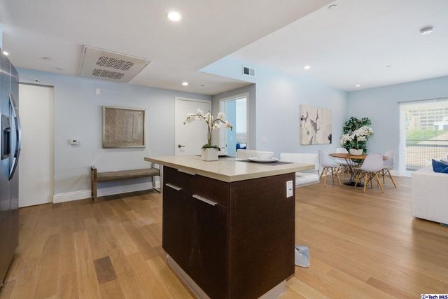 a kitchen with kitchen island granite countertop a sink cabinets and stainless steel appliances