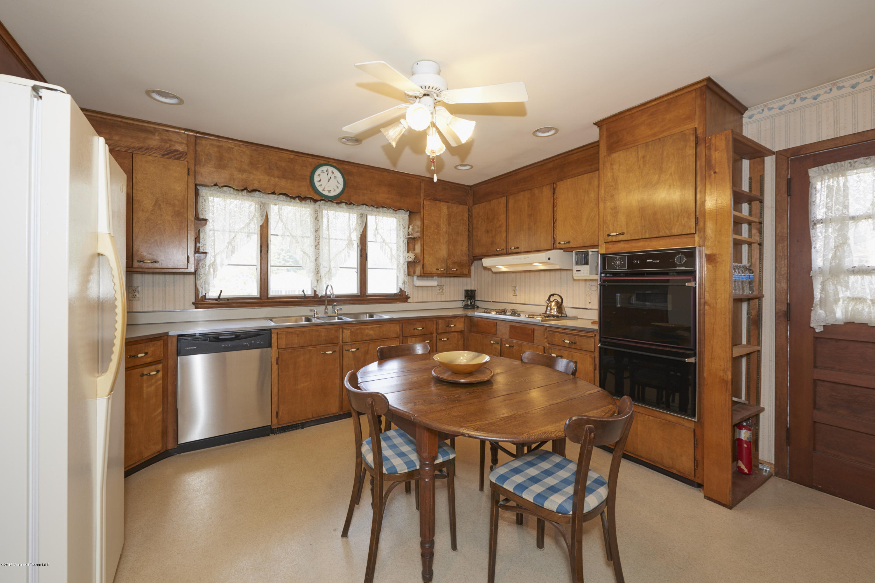 22 Maple Avenue Little Silver, NJ 07739 - Photo 7 of 25 a kitchen with stainless steel appliances granite countertop a stove refrigerator a sink dishwasher a dining table and chairs with wooden floor