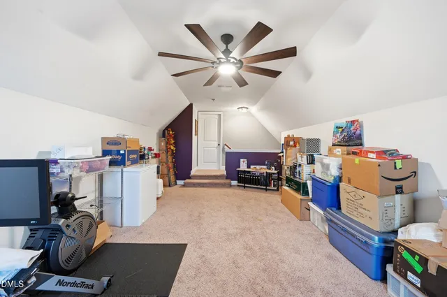a room with furniture a ceiling fan and a window