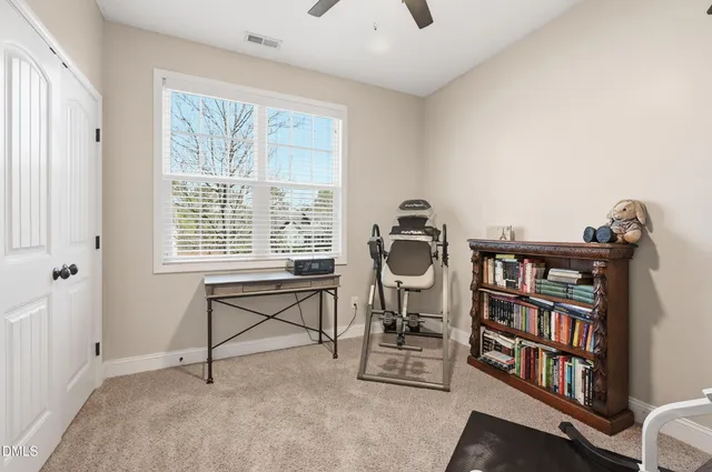 a view of a workspace with furniture and a book shelf