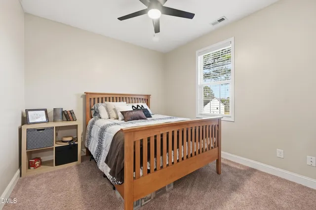 a bed sitting in a bedroom next to a window