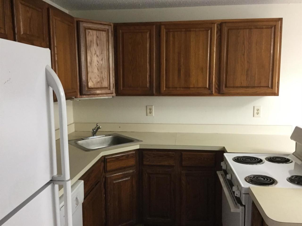 174 Lowell Road, Unit 57 Mashpee, MA 02649 - Photo 5 of 12 a kitchen with a sink stove and cabinets