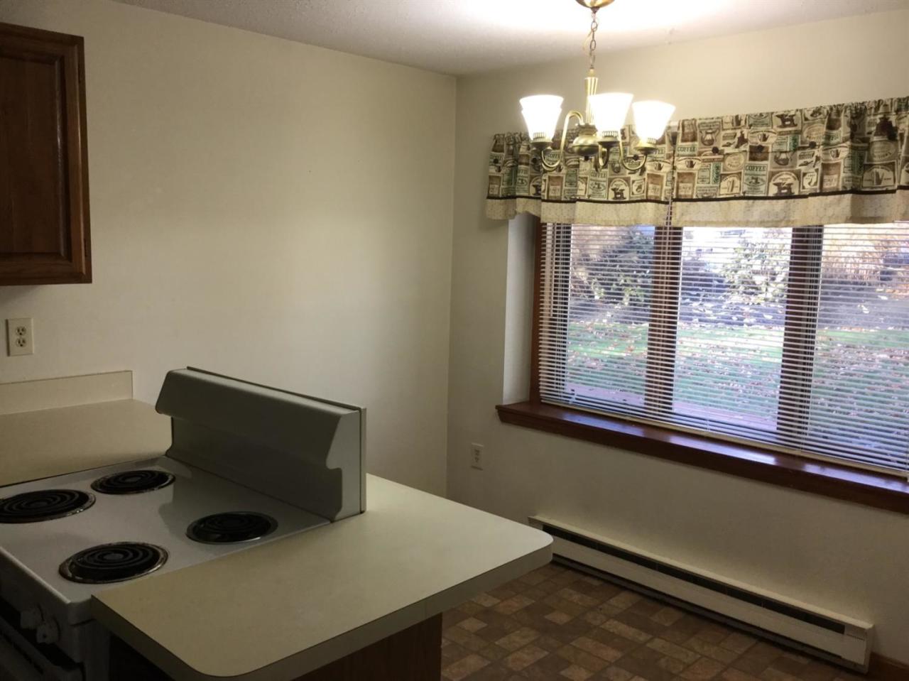 174 Lowell Road, Unit 57 Mashpee, MA 02649 - Photo 6 of 12 a dining room with wooden floor and windows
