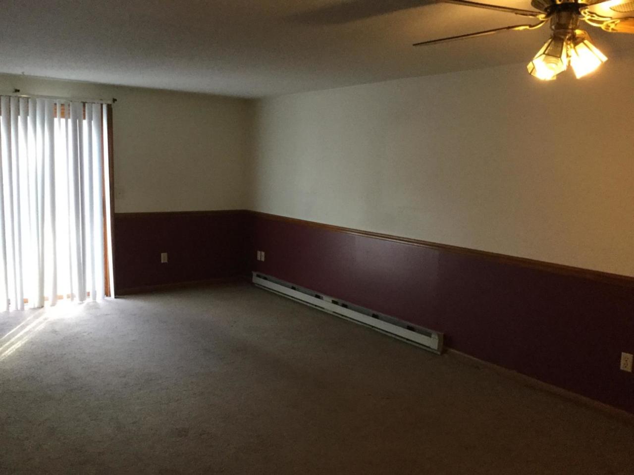 174 Lowell Road, Unit 57 Mashpee, MA 02649 - Photo 8 of 12 an empty room with a window and a fan