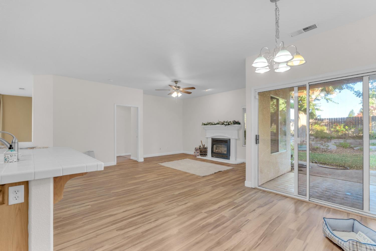 2573 Applegate Avenue Clovis, CA 93611 - Photo 20 of 26 a view of a livingroom with a ceiling fan a fireplace and wooden floor