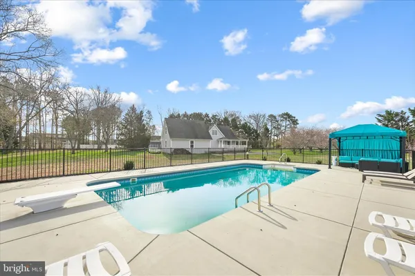 a swimming pool with outdoor seating and yard