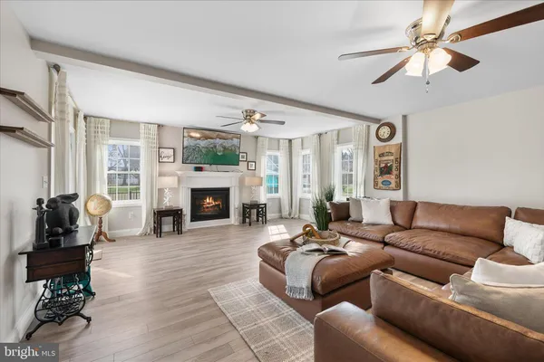 a living room with furniture fireplace and a large window
