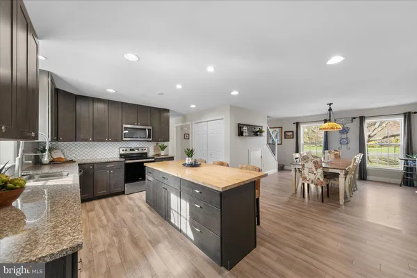 a large kitchen with kitchen island a sink table and chairs