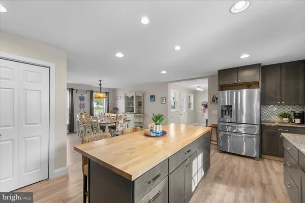 a kitchen with stainless steel appliances kitchen island granite countertop a refrigerator and a sink