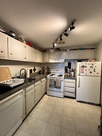 a kitchen with a white cabinets and white appliances