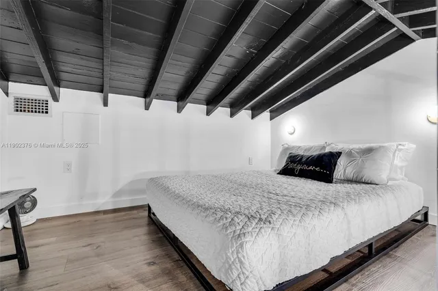 a bedroom with a bed with wooden floor