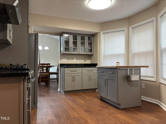 a kitchen with kitchen island granite countertop a sink cabinets and wooden floor
