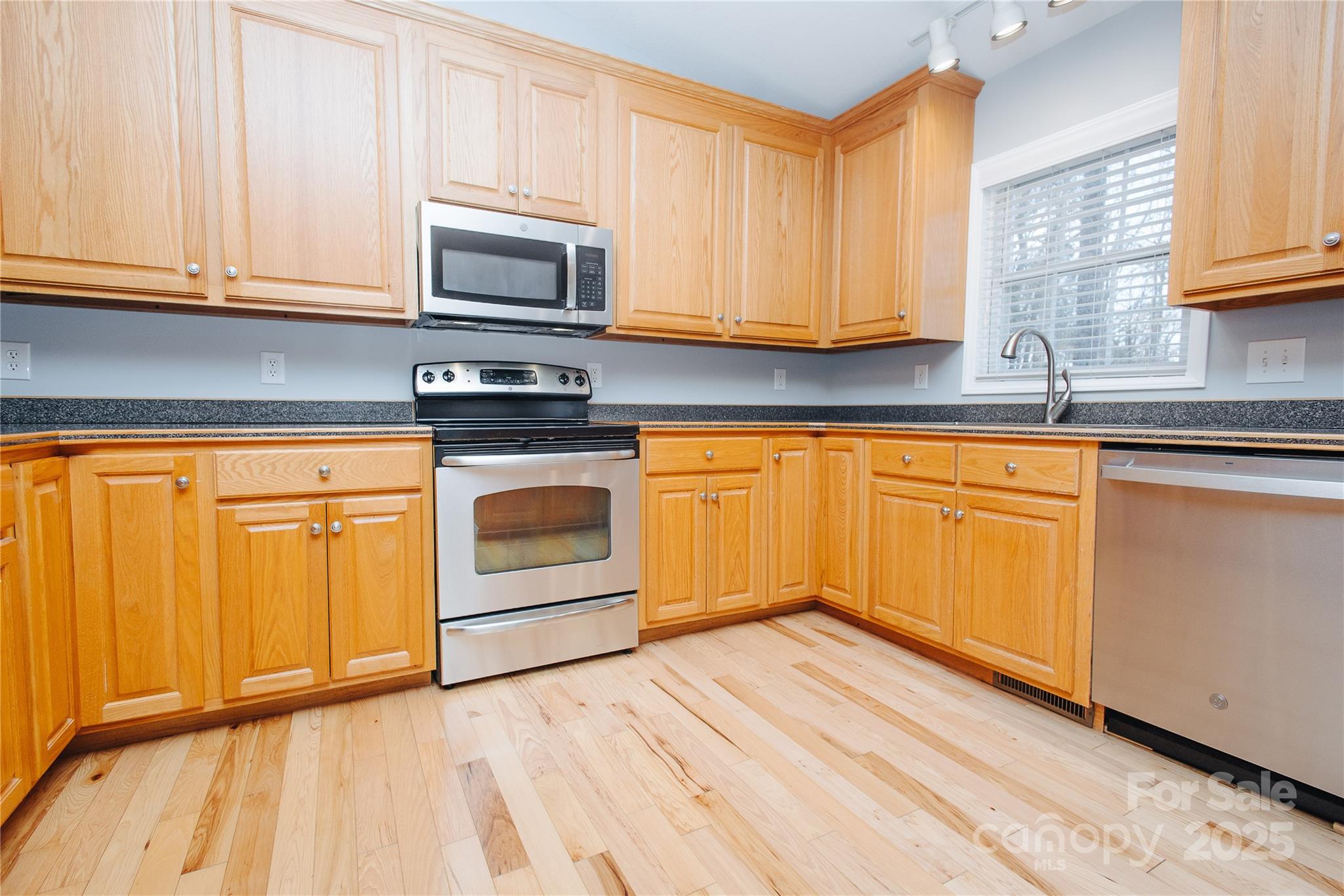 89 Bobcat Path Marion, NC 28752 - Photo 20 of 48 a kitchen with granite countertop wooden cabinets stainless steel appliances and a sink