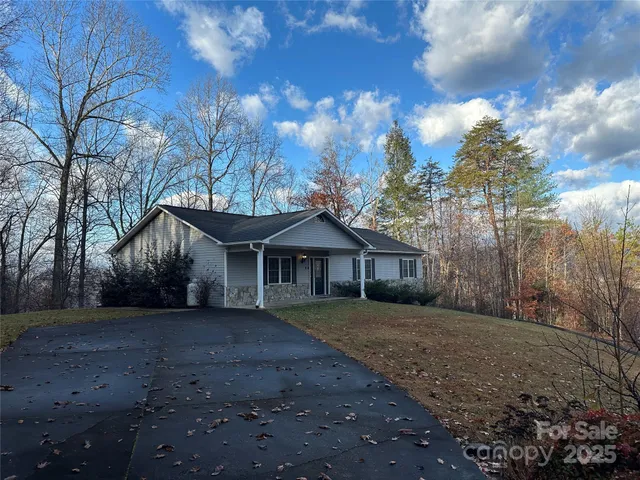a front view of a house with a yard and trees