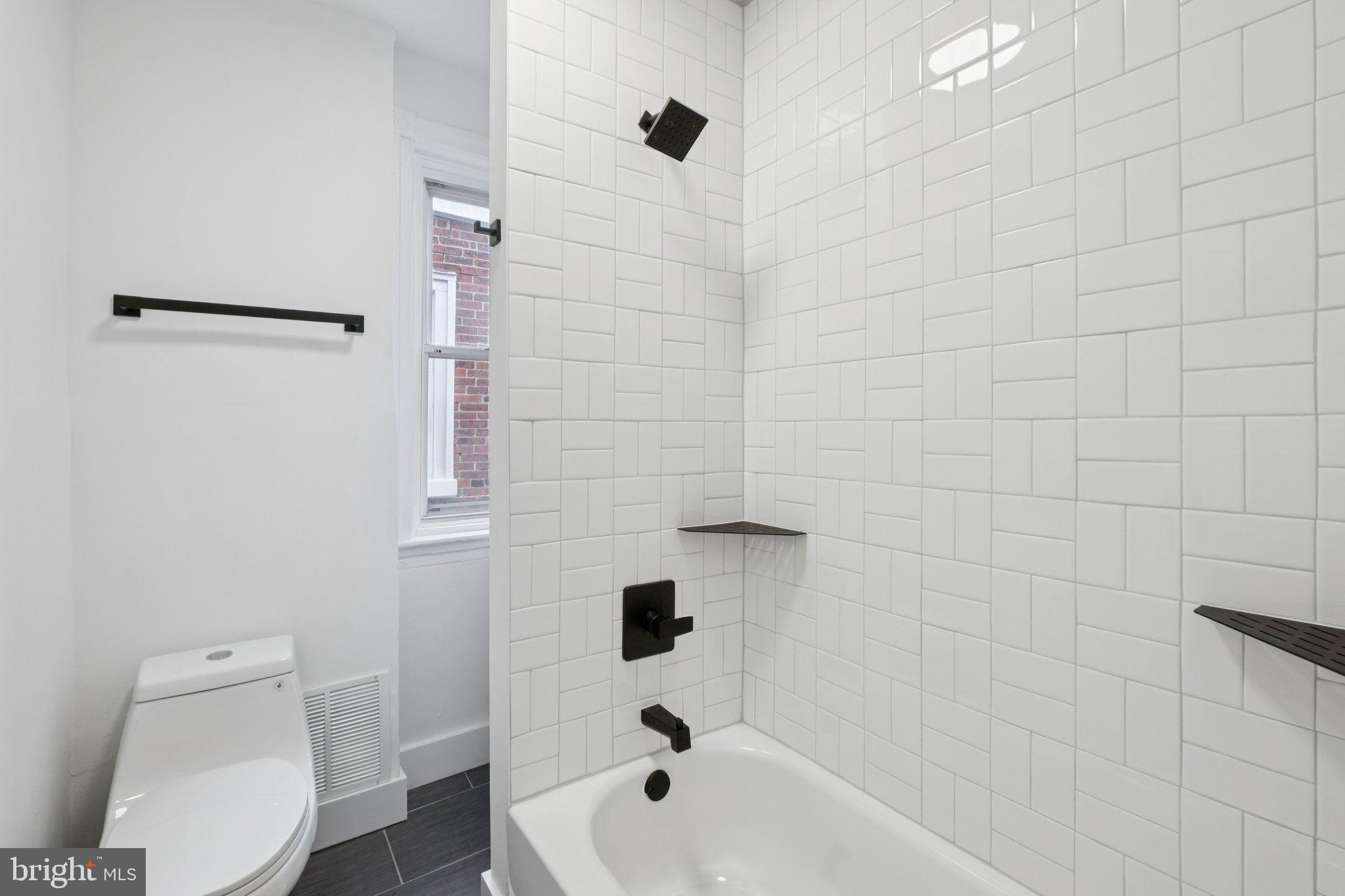 6638 Ross Street Philadelphia, PA 19119 - Photo 16 of 18 a bathroom with a bathtub a toilet and a shower