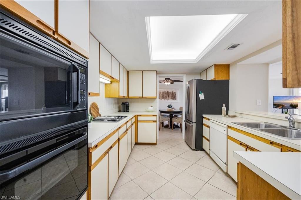 5601 Turtle Bay Drive, Unit 2003 Naples, FL 34108 - Photo 12 of 19 a kitchen with a refrigerator and a sink