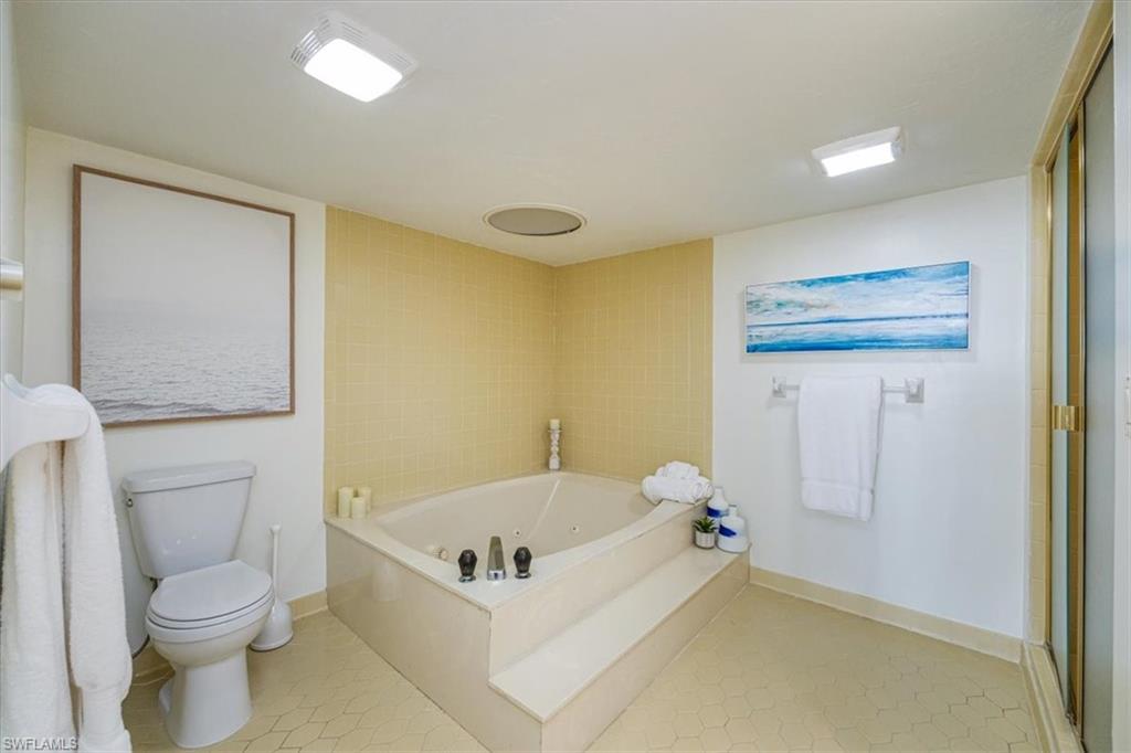 5601 Turtle Bay Drive, Unit 2003 Naples, FL 34108 - Photo 17 of 19 a bathroom with a tub and toilet