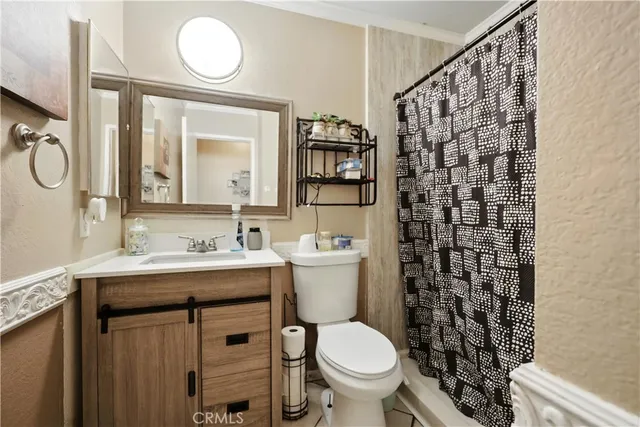 a bathroom with a granite countertop sink toilet and a mirror