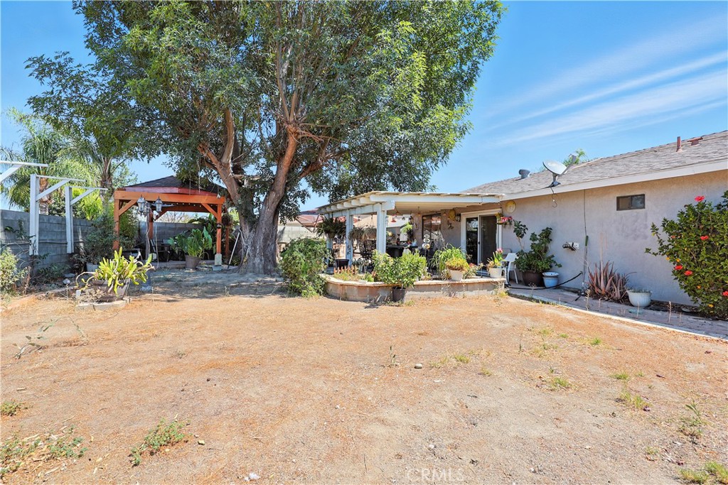 769 Harding Street Hemet, CA 92543 - Photo 22 of 29 a patio with a table and chairs under an umbrella