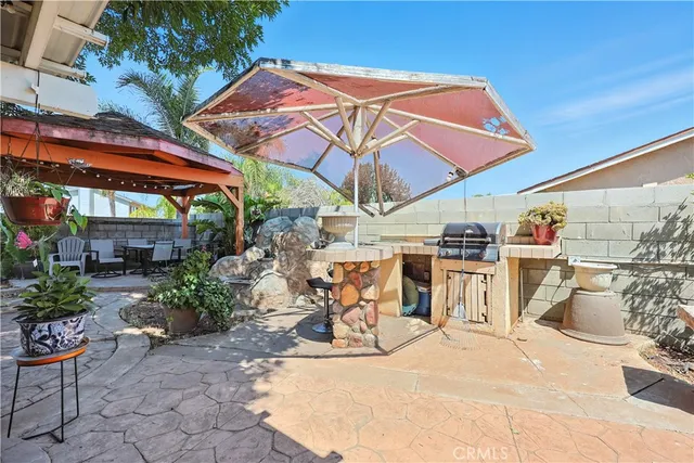 a view of a patio with a table and chairs under an umbrella