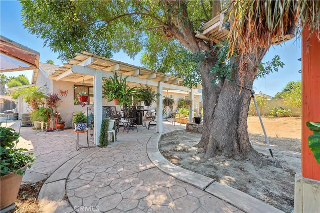 a view of a patio with table and chairs under an umbrella