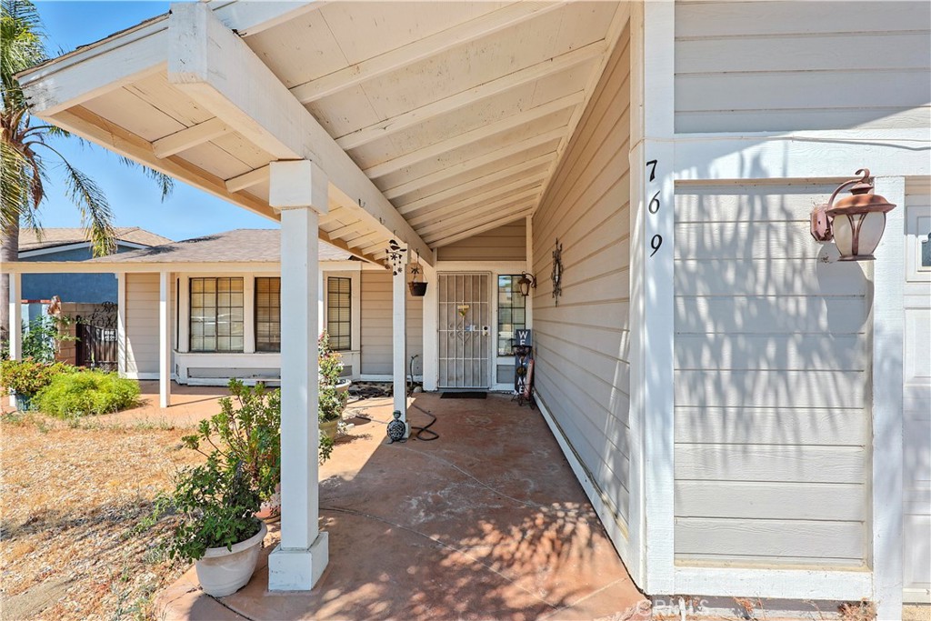 769 Harding Street Hemet, CA 92543 - Photo 3 of 29 a view of a porch with a floor to ceiling window and potted plants