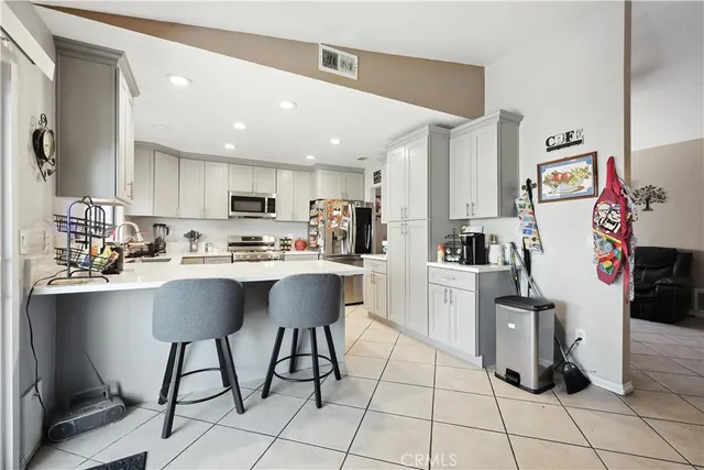 a kitchen with granite countertop a sink cabinets and stainless steel appliances