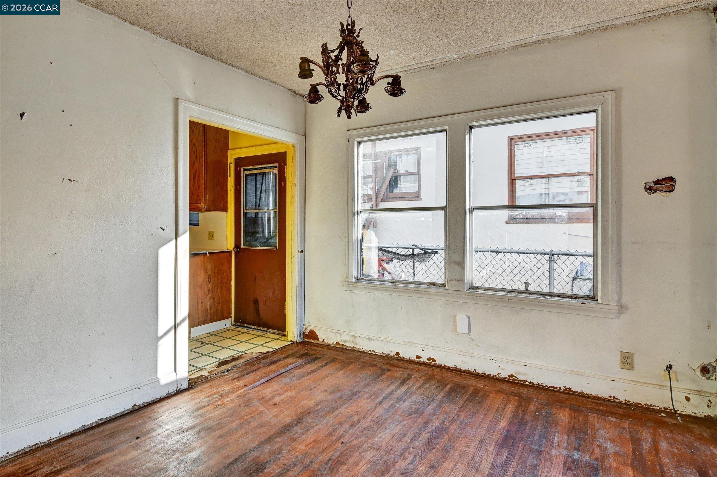 1711 Carleton Street Berkeley, CA 94703 - Photo 8 of 40 an empty room with wooden floor chandelier and windows