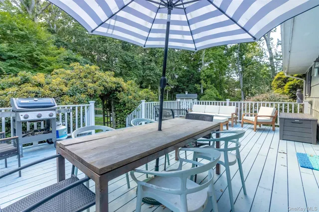 a view of a patio with table and chairs under an umbrella with wooden floor