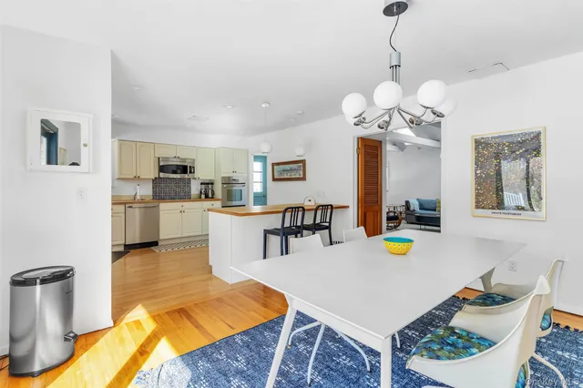 a living room with dining table a table chairs and a kitchen view