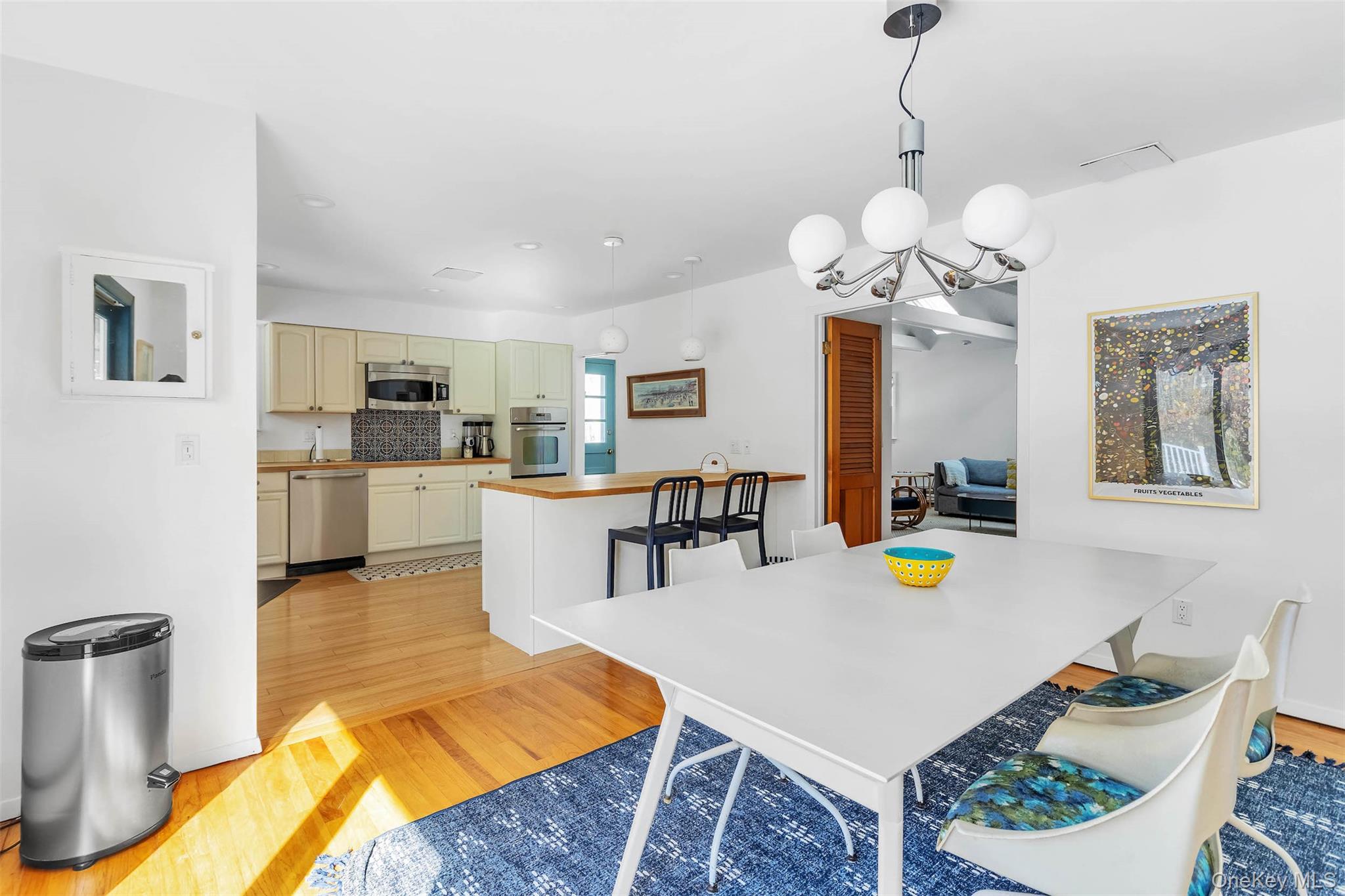 485 Pine Road Southold, NY 11971 - Photo 10 of 39 a living room with dining table a table chairs and a kitchen view