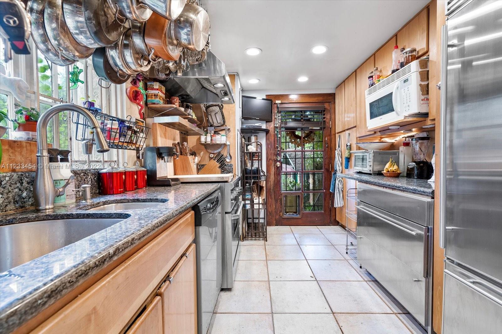 3041 Oak Avenue Coconut Grove, FL 33133 - Photo 14 of 31 a kitchen with stainless steel appliances granite countertop a sink and a refrigerator