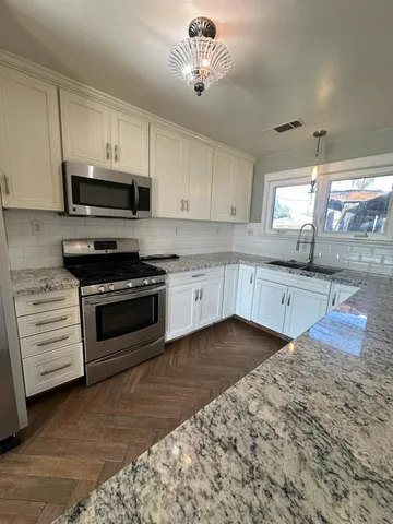 a kitchen with stainless steel appliances granite countertop a sink and cabinets
