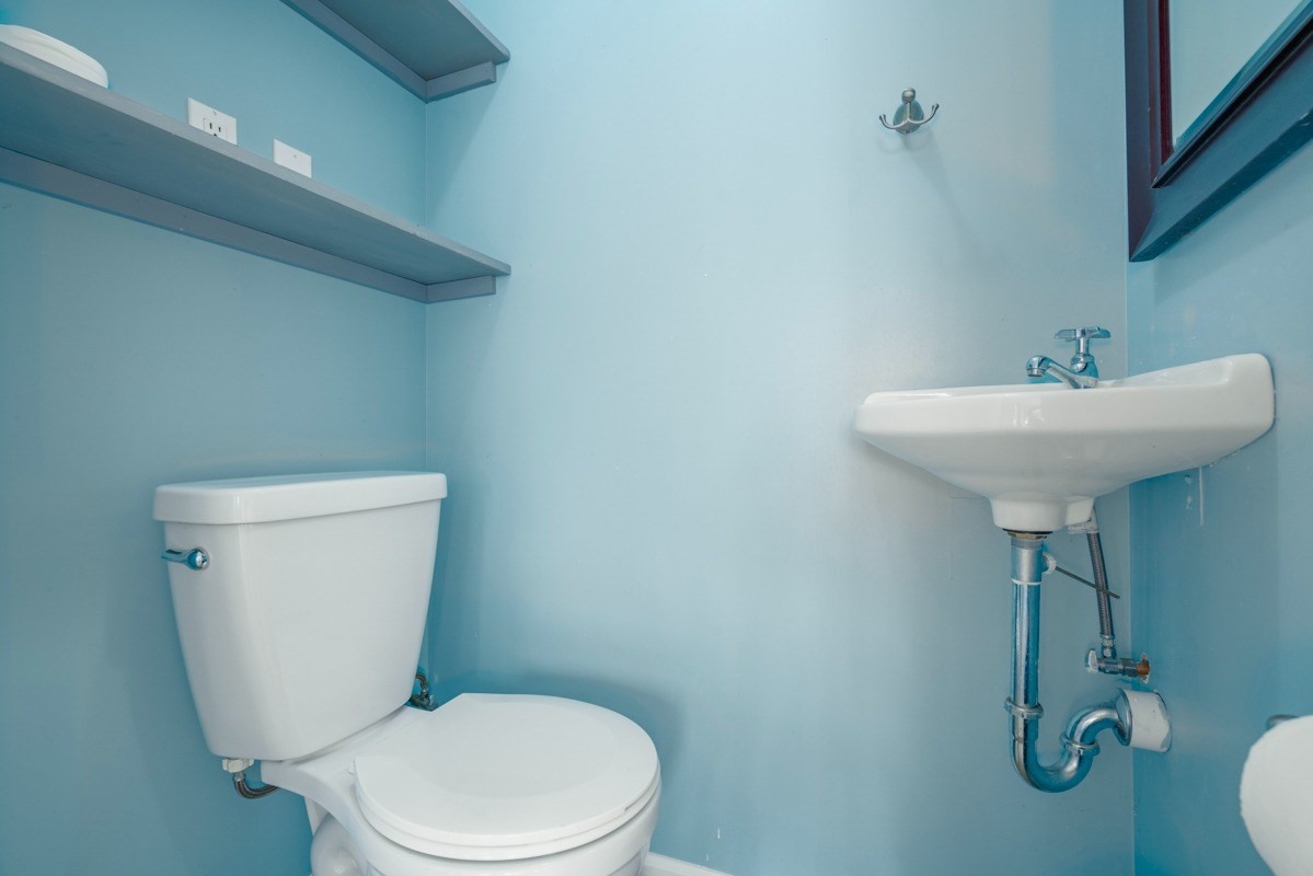 27-571 Kalaoa Camp Road Papaikou, HI 96781 - Photo 16 of 29 a white toilet sitting next to a bathroom sink