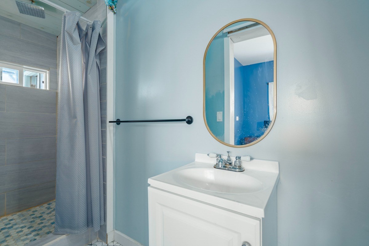 27-571 Kalaoa Camp Road Papaikou, HI 96781 - Photo 18 of 29 a bathroom with a sink vanity and a mirror