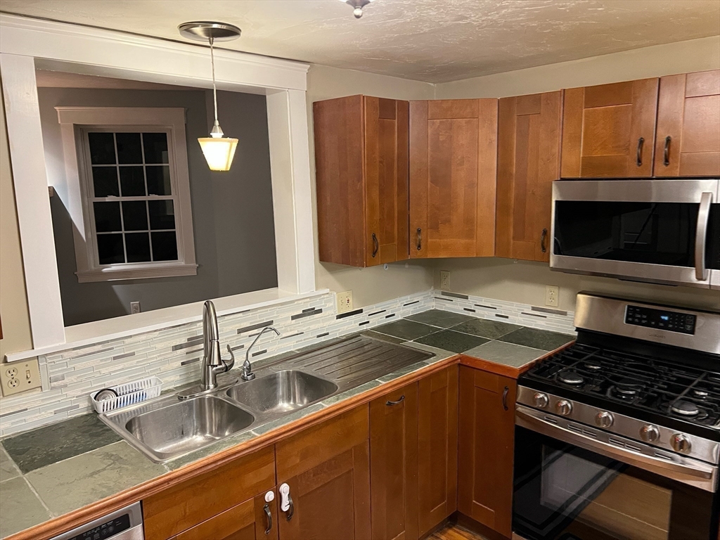 60 Edgehill Road Braintree, MA 02184 - Photo 12 of 30 a kitchen with a sink stove and microwave