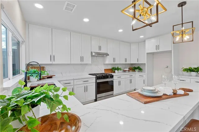 a kitchen with a white stove top oven and white cabinets