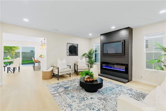 a living room with furniture a flat screen tv and a fireplace