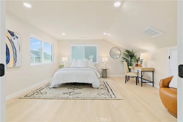 a spacious bedroom with a bed and a dresser