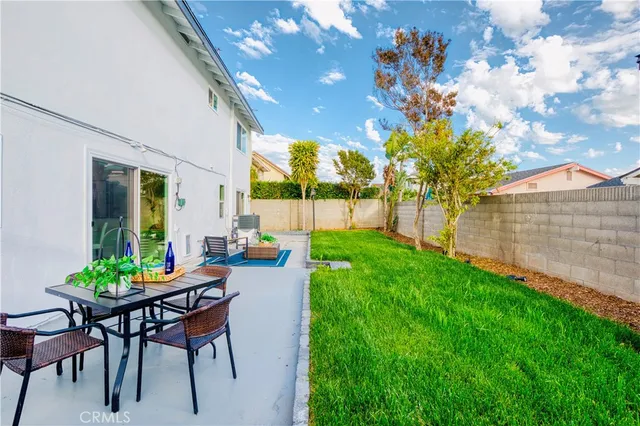 a front view of a house with a yard and potted plants