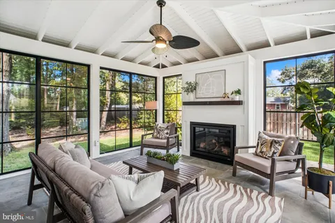 a living room with furniture fireplace and a large window