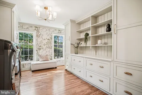 a living room with furniture cabinets and wooden floor