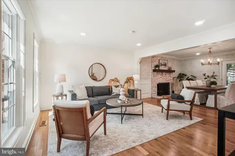 a living room with fireplace furniture and a large window