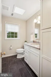 a bathroom with a toilet a sink and a mirror