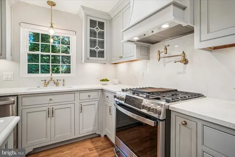 a kitchen with kitchen island a dining table chairs and a wooden floor